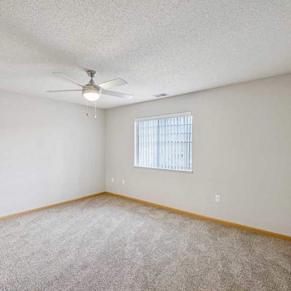 Thumbnail 4 of 13 A room with a ceiling fan and a window with blinds.