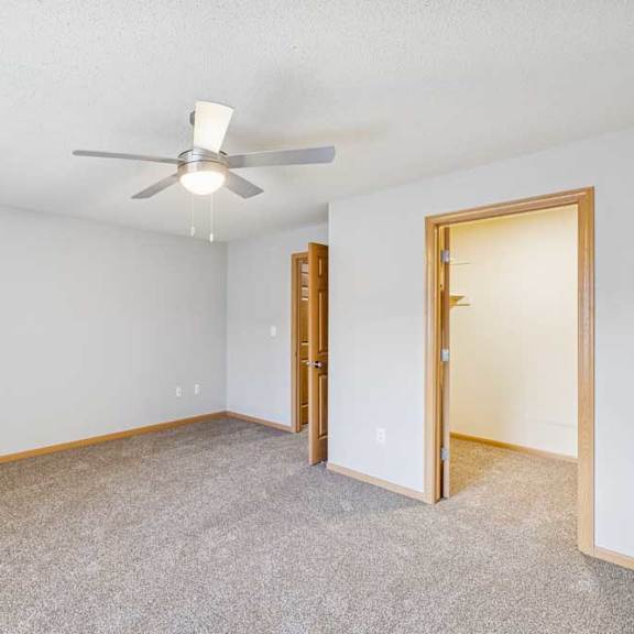 Thumbnail 10 of 13 A room with a ceiling fan and carpeted floor.