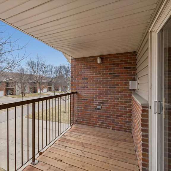Thumbnail 21 of 40 A balcony with a metal railing and a brick wall.