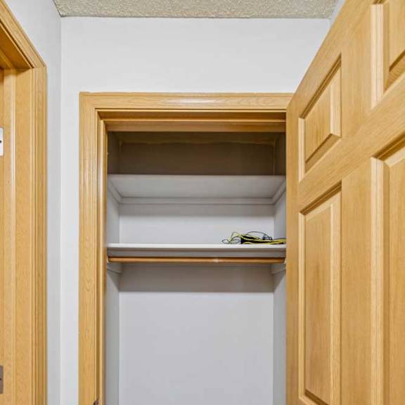 Thumbnail 23 of 40 A small closet with a shelf and a pair of glasses on it.