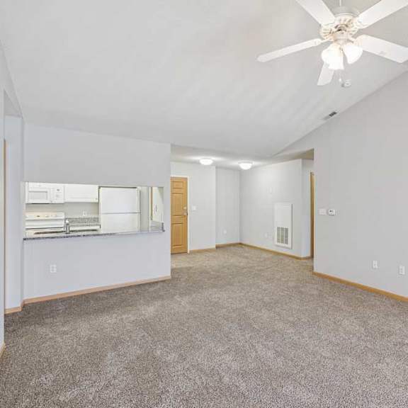 Thumbnail 38 of 40 A spacious room with a ceiling fan and carpeted floor.