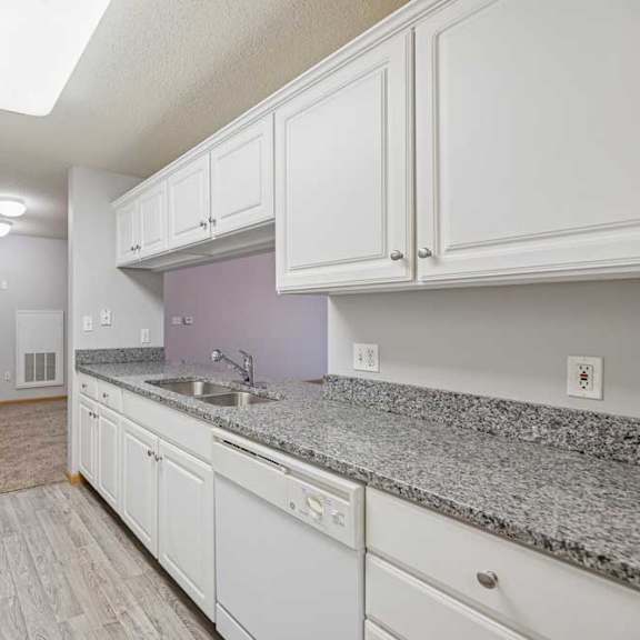 Thumbnail 24 of 40 A kitchen with white appliances and cabinets.
