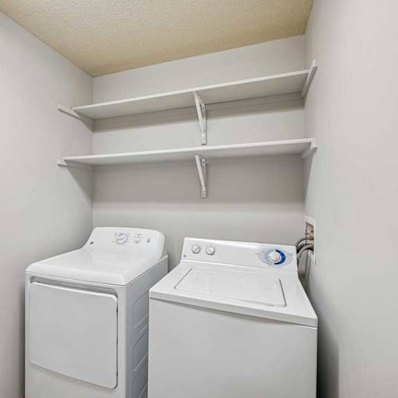 Thumbnail 36 of 40 Two white front loading washing machines in a small laundry room.