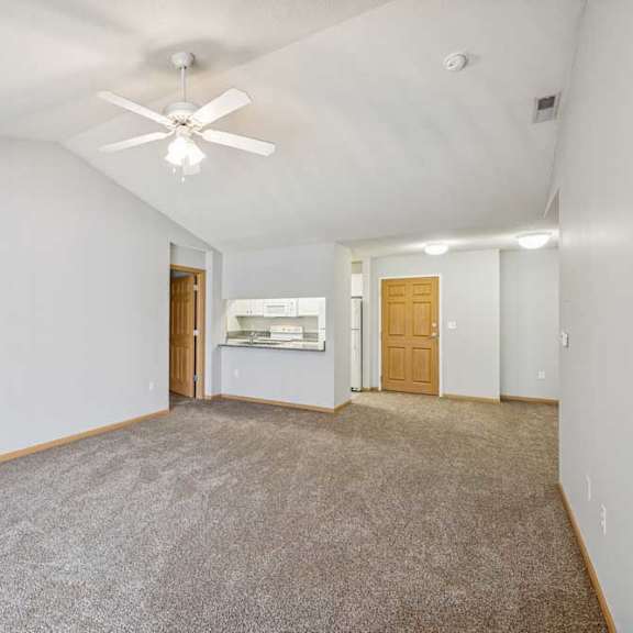 Thumbnail 37 of 40 A spacious room with a ceiling fan and carpeted floor.