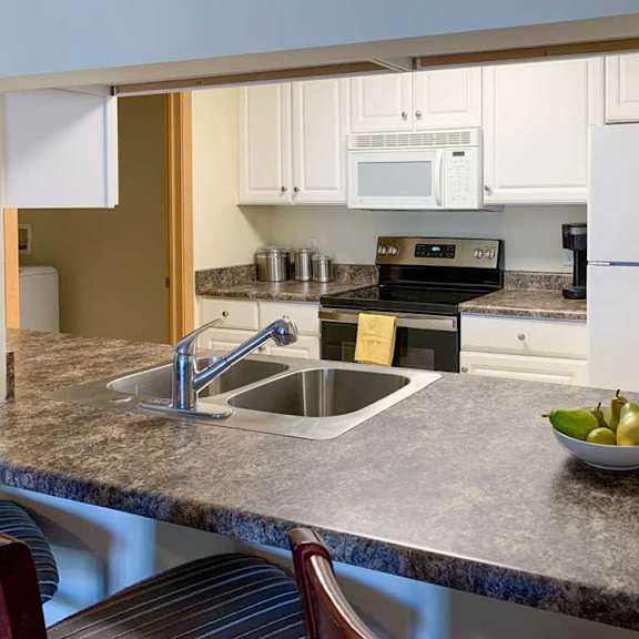 Thumbnail 20 of 20 a kitchen with a bar top style counter, a sink, stove, and refrigerator