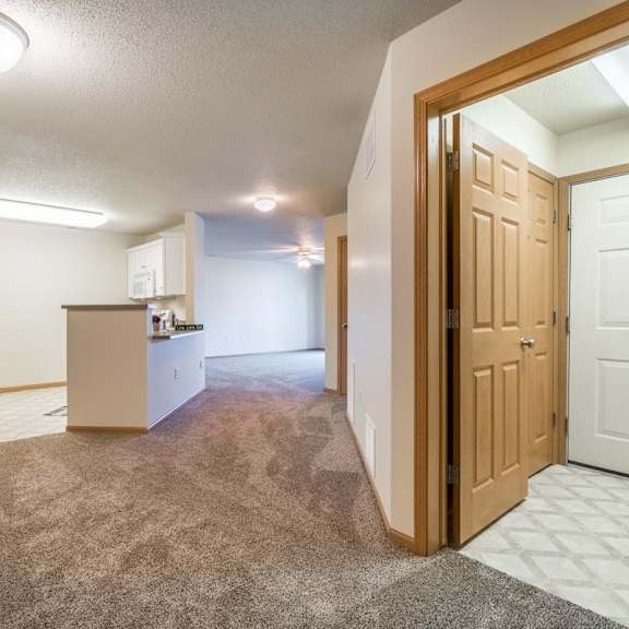 Thumbnail 2 of 11 A kitchen with white cabinets and a refrigerator is visible through an open door.