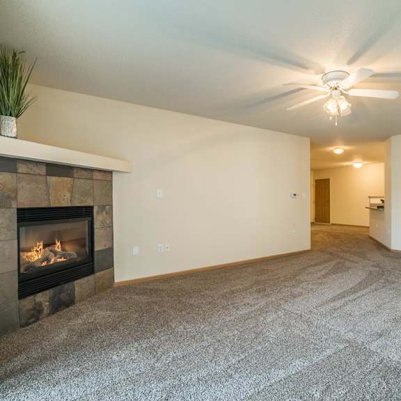 Thumbnail 8 of 11 A living room with a fireplace and a grey carpet.