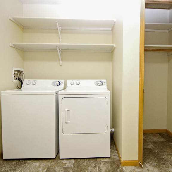 Thumbnail 5 of 12 A small laundry room with a washer and dryer.