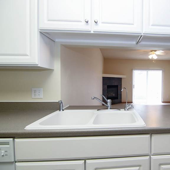 Thumbnail 7 of 12 A kitchen with white cabinets and a sink.