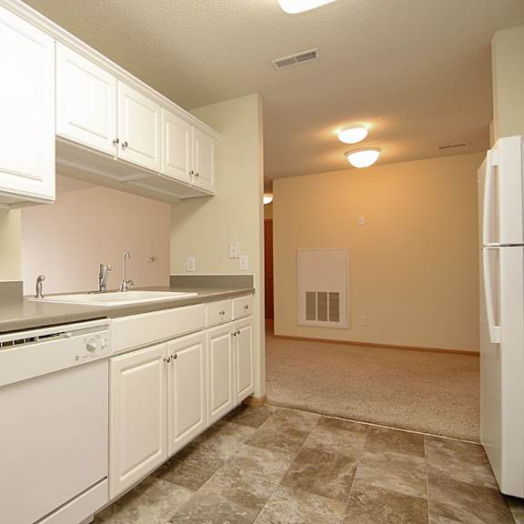 Thumbnail 6 of 12 A kitchen with white cabinets and appliances.