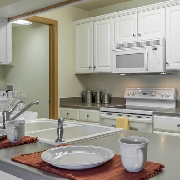 Thumbnail 7 of 20 A kitchen with white cabinets and a white fridge.