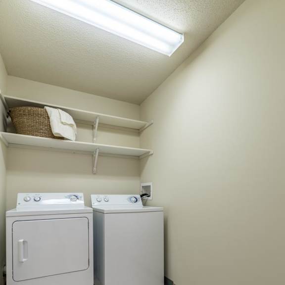 Thumbnail 10 of 20 Two white washing machines in a laundry room.