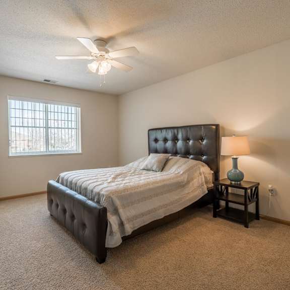 Thumbnail 15 of 20 A bedroom with a bed, a nightstand, and a ceiling fan.