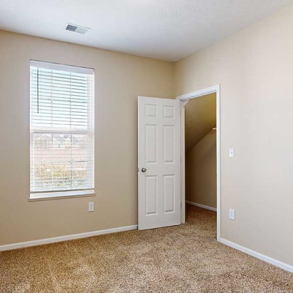 Thumbnail 25 of 28 a bedroom with a closet and a tall window