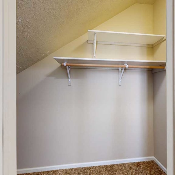 Thumbnail 26 of 28 a slanted closet with a built-in shelves and hanging rod