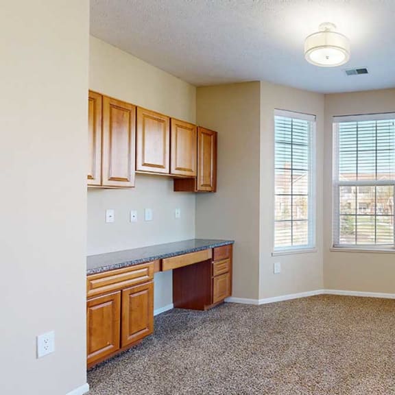 Thumbnail 6 of 28 a living room with a bay window and built-in desk, providing a bright and functional workspace
