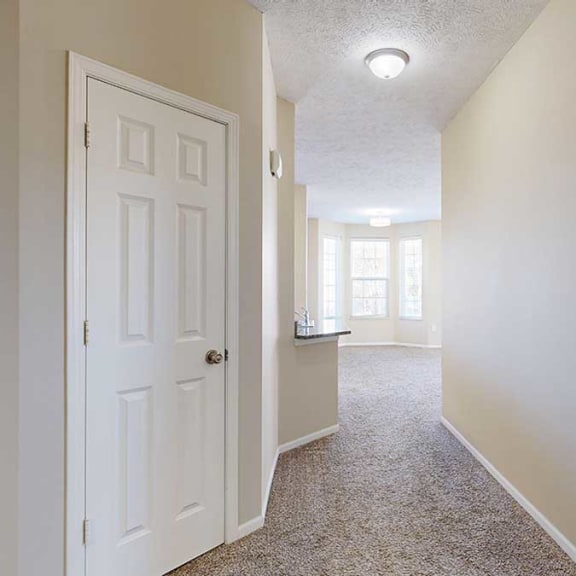 Thumbnail 3 of 28 a hallway with a coat closet and a small mechanical closet
