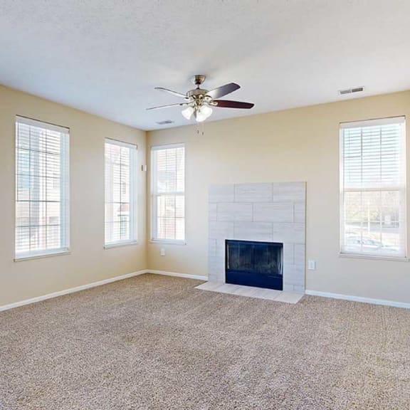 Thumbnail 4 of 28 a large living room featuring multiple windows, a modern tiled fireplace, and carpeted flooring