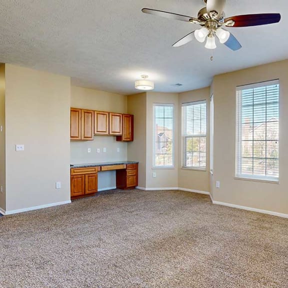 Thumbnail 7 of 28 a living room with carpet, a ceiling fan, a built-in desk, and large windows