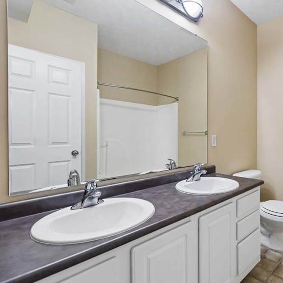 Thumbnail 34 of 34 A bathroom with a toilet, sink, and mirror.