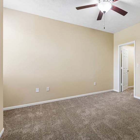 Thumbnail 33 of 34 A room with a ceiling fan and carpeted floor.