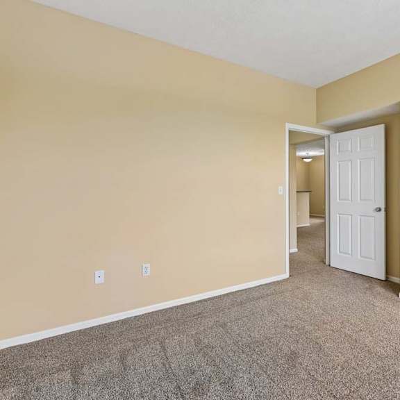 Thumbnail 23 of 34 A room with a carpeted floor and a white door.