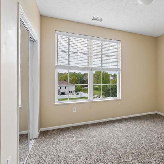 Thumbnail 24 of 34 A room with a large window and a carpeted floor.