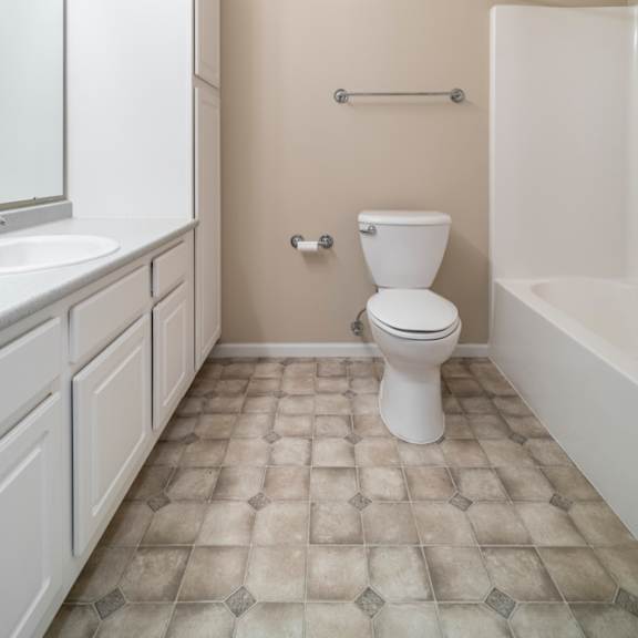 Thumbnail 13 of 16 A white toilet sits in a bathroom with a white sink and a white bathtub.