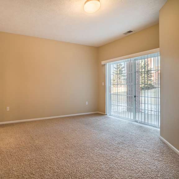 Thumbnail 8 of 16 A room with carpeted floor and sliding glass doors.