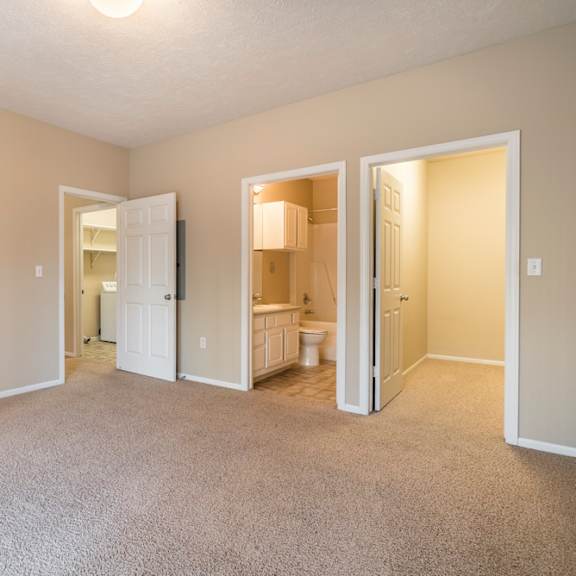 Thumbnail 9 of 16 A carpeted room with doorways leading to the hallway, bathroom, and closet