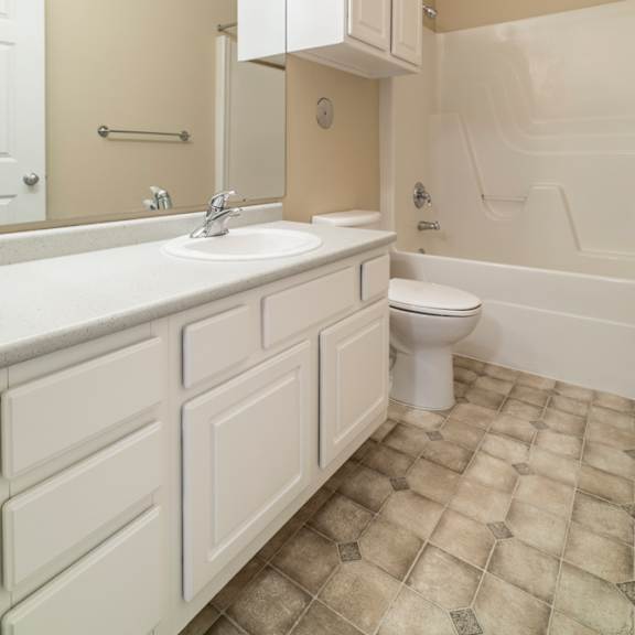 Thumbnail 10 of 16 A white bathroom with a toilet, sink, and bathtub.