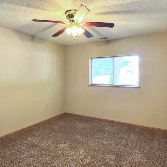 Thumbnail 9 of 11 a bedroom with a ceiling fan and a window