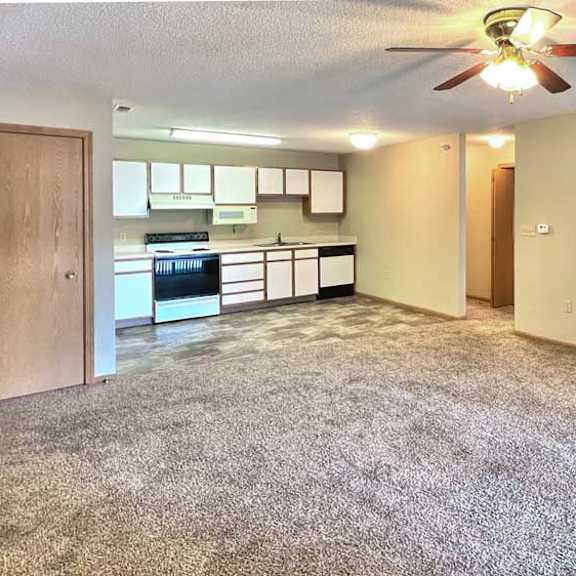 Thumbnail 5 of 11 a living room with a carpeted floor and a ceiling fan