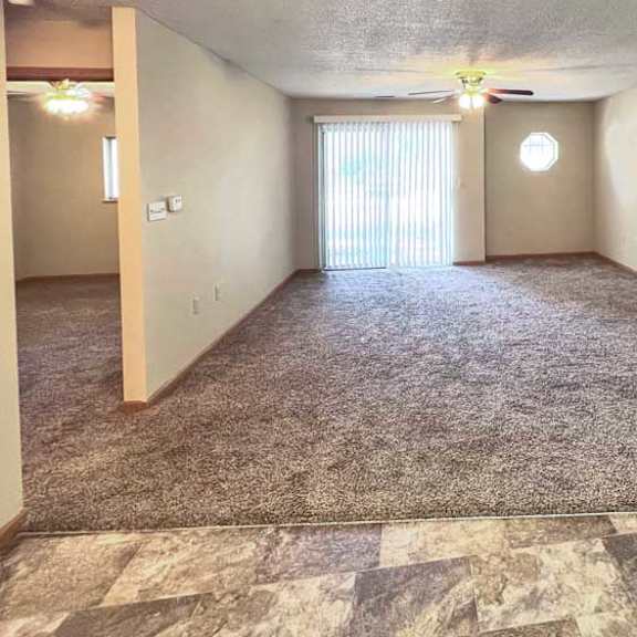 Thumbnail 3 of 11 a living room with a carpeted floor and a ceiling fan
