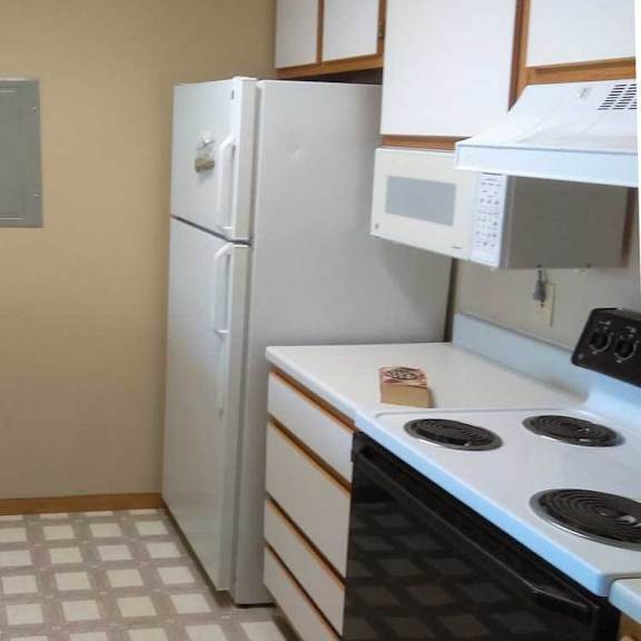 Thumbnail 6 of 11 a kitchen with white appliances, white and brown cabinets, and vinyl flooring
