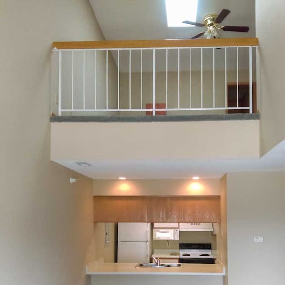 Thumbnail 7 of 11 a kitchen open to the living room with a loft balcony above it