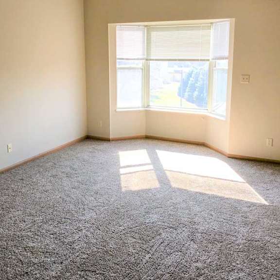 Thumbnail 4 of 11 a living room with a carpeted floor and a window letting in sunlight