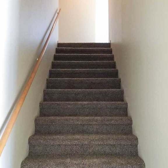 Thumbnail 8 of 11 a staircase with a wooden handrail and carpeted steps