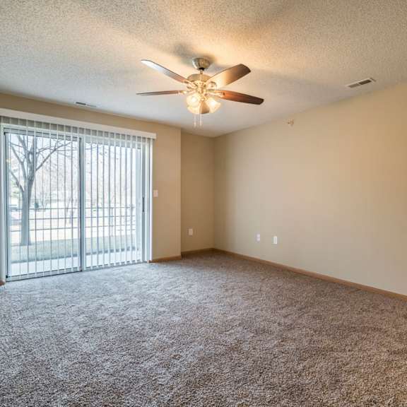 Thumbnail 2 of 12 A room with a ceiling fan and carpeted floor.