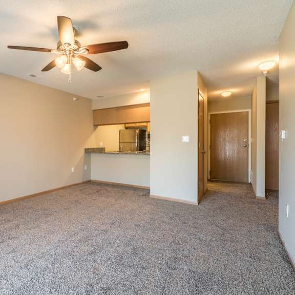 Thumbnail 3 of 12 A room with a ceiling fan and carpeted floor.