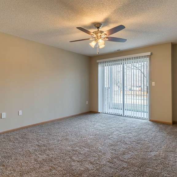 Thumbnail 4 of 12 A room with a ceiling fan and carpeted floor.