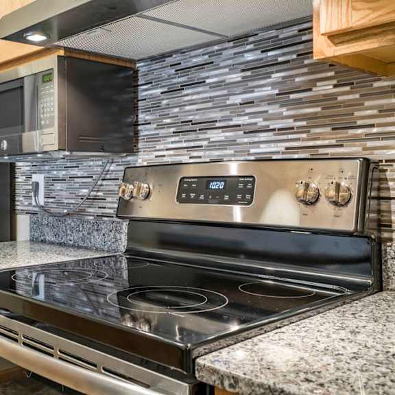 Thumbnail 6 of 12 A modern kitchen with a black stove top oven and a black refrigerator.