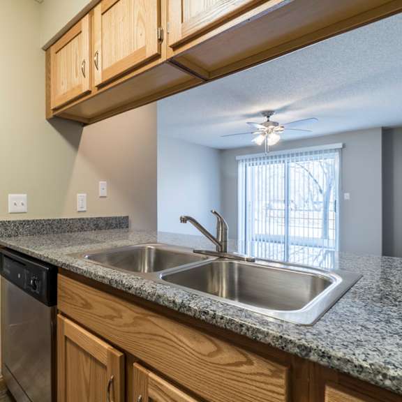 Thumbnail 7 of 12 A kitchen with granite countertops and stainless steel appliances.