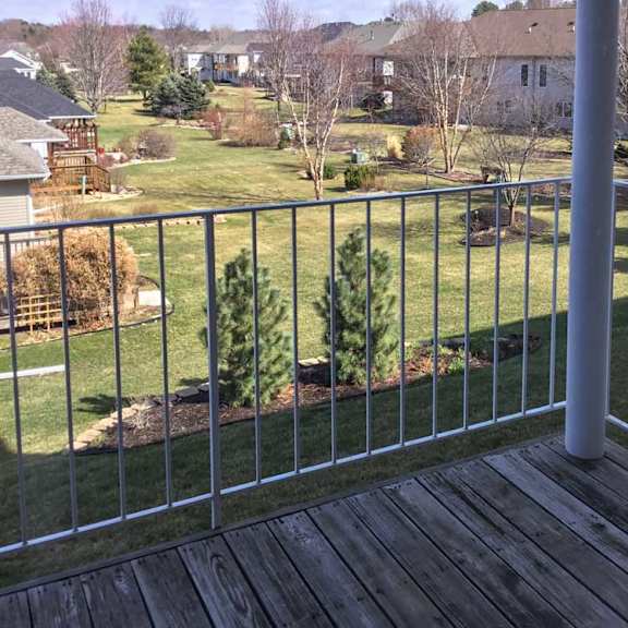Thumbnail 13 of 24 a view from a balcony overlooking a green lawn and trees