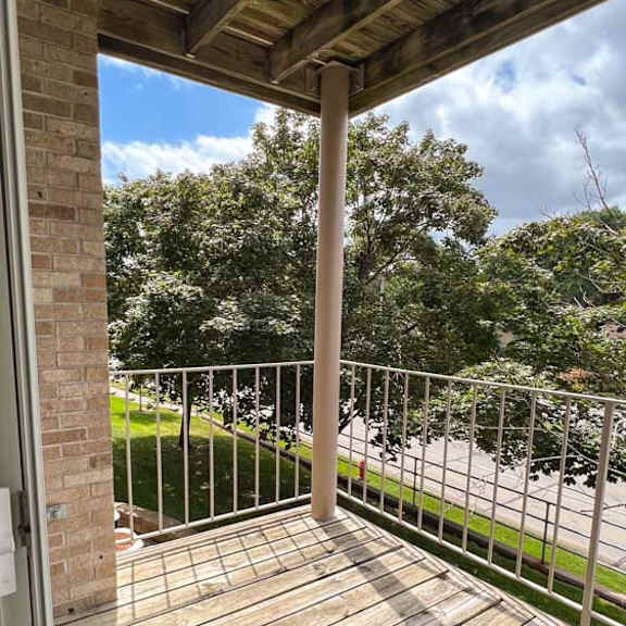 Thumbnail 12 of 24 a wooden balcony deck with a metal railing