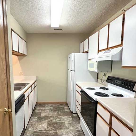 Thumbnail 7 of 24 a kitchen with a vinyl tiled floor and white and brown cabinets