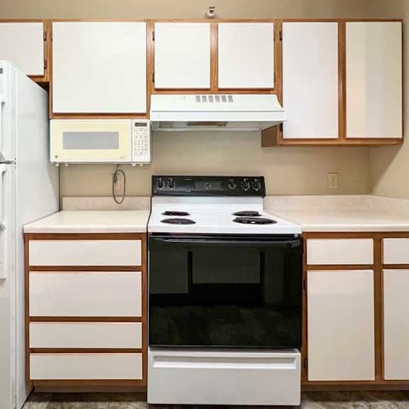 Thumbnail 9 of 24 a kitchen with white white appliances and white and brown cabinets
