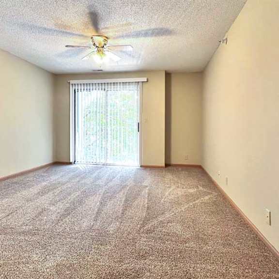Thumbnail 2 of 24 a living room with a carpeted floor and a ceiling fan