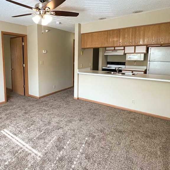 Thumbnail 2 of 9 a living room with a ceiling fan and carpeted flooring