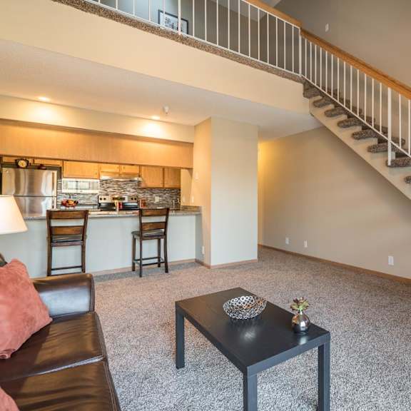 Thumbnail 6 of 16 A living room with a staircase leading to the upper floor.